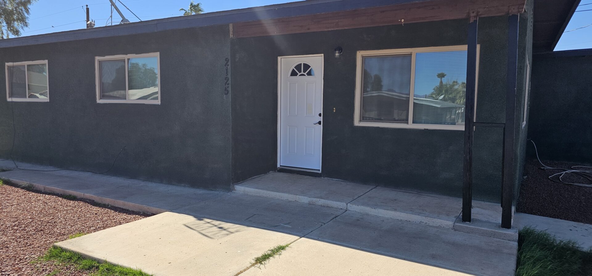 Dark gray house with white door.