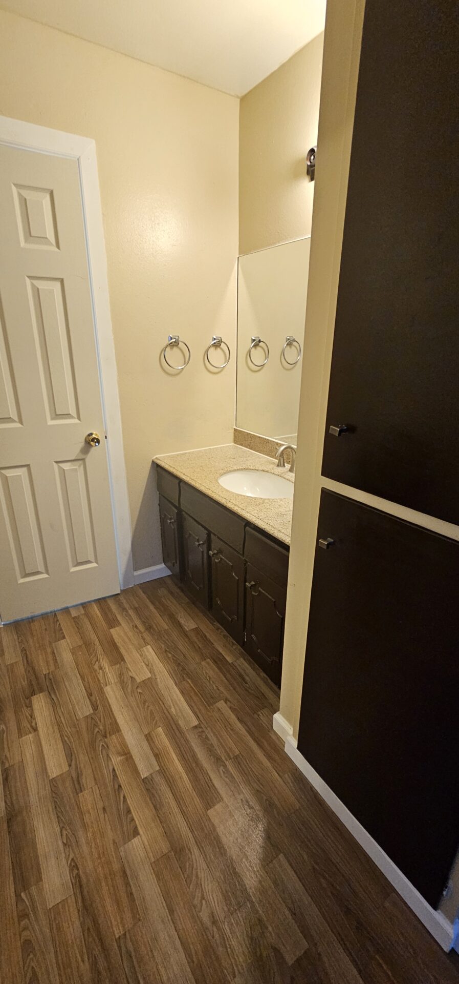 Small bathroom with vanity and wood floor.
