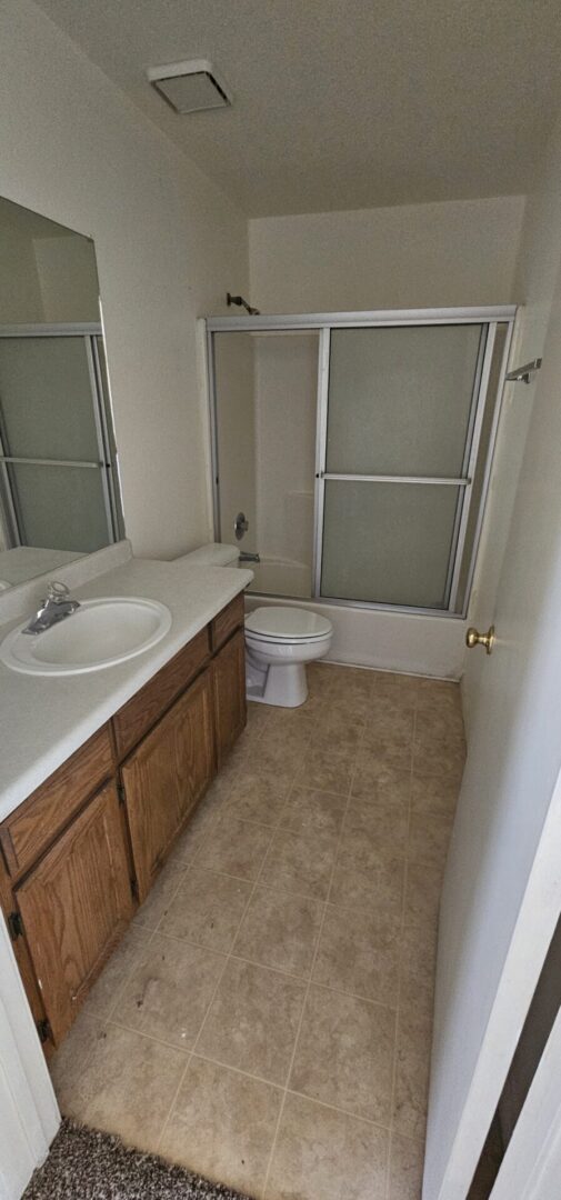 Small bathroom with shower and vanity.