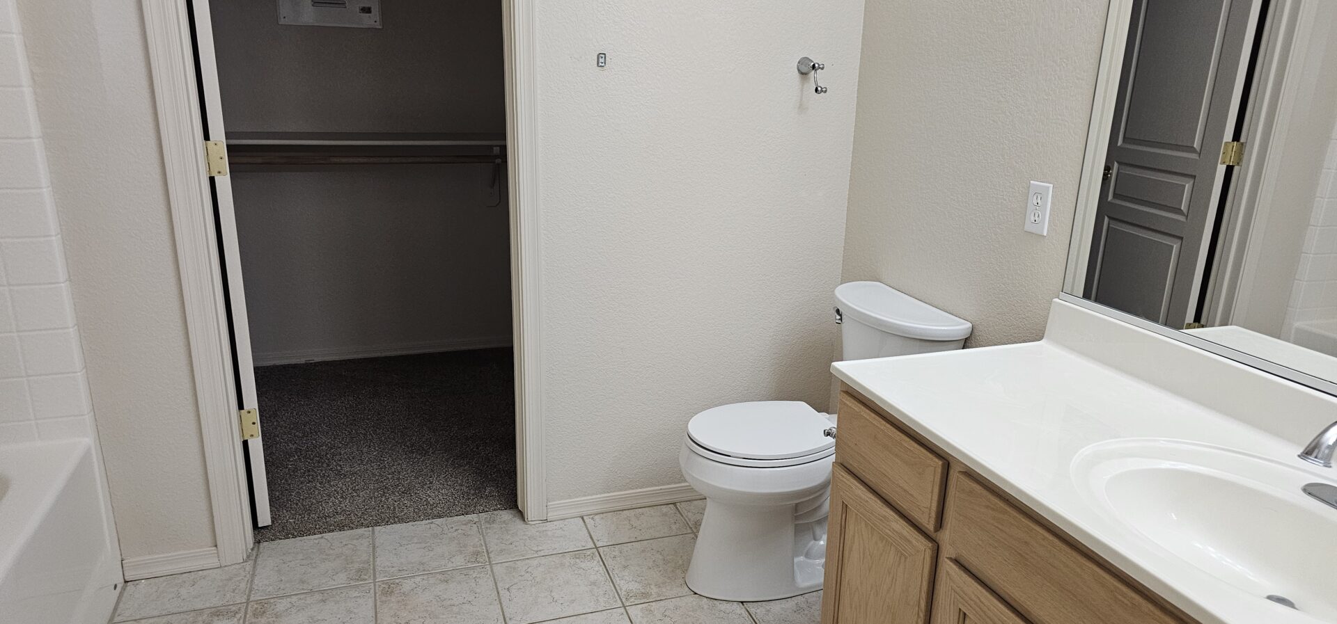 Bathroom with toilet, sink, and closet.