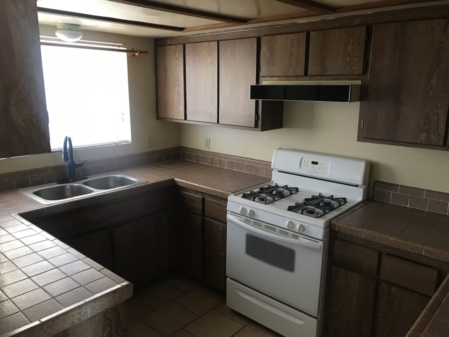 Kitchen with stove, sink, and cabinets.