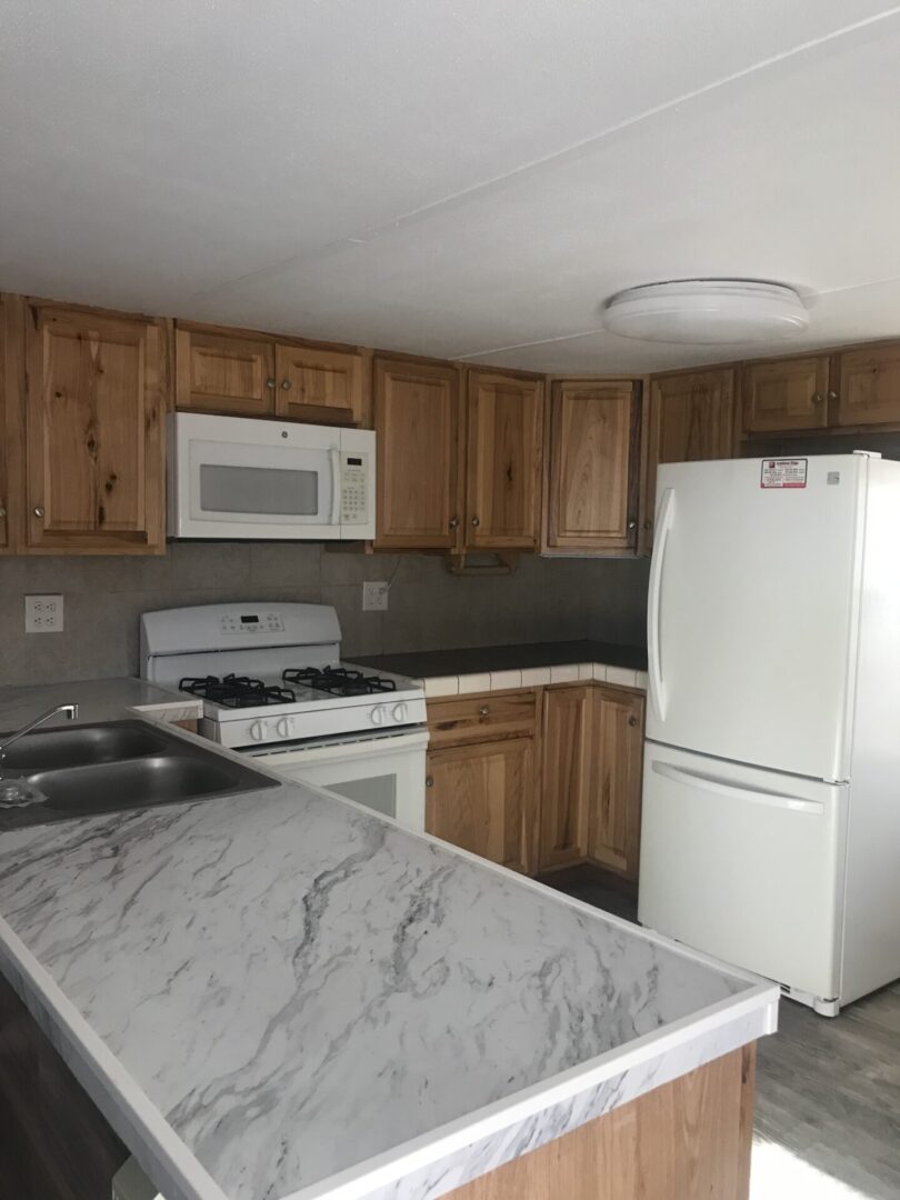White kitchen with wood cabinets and island.
