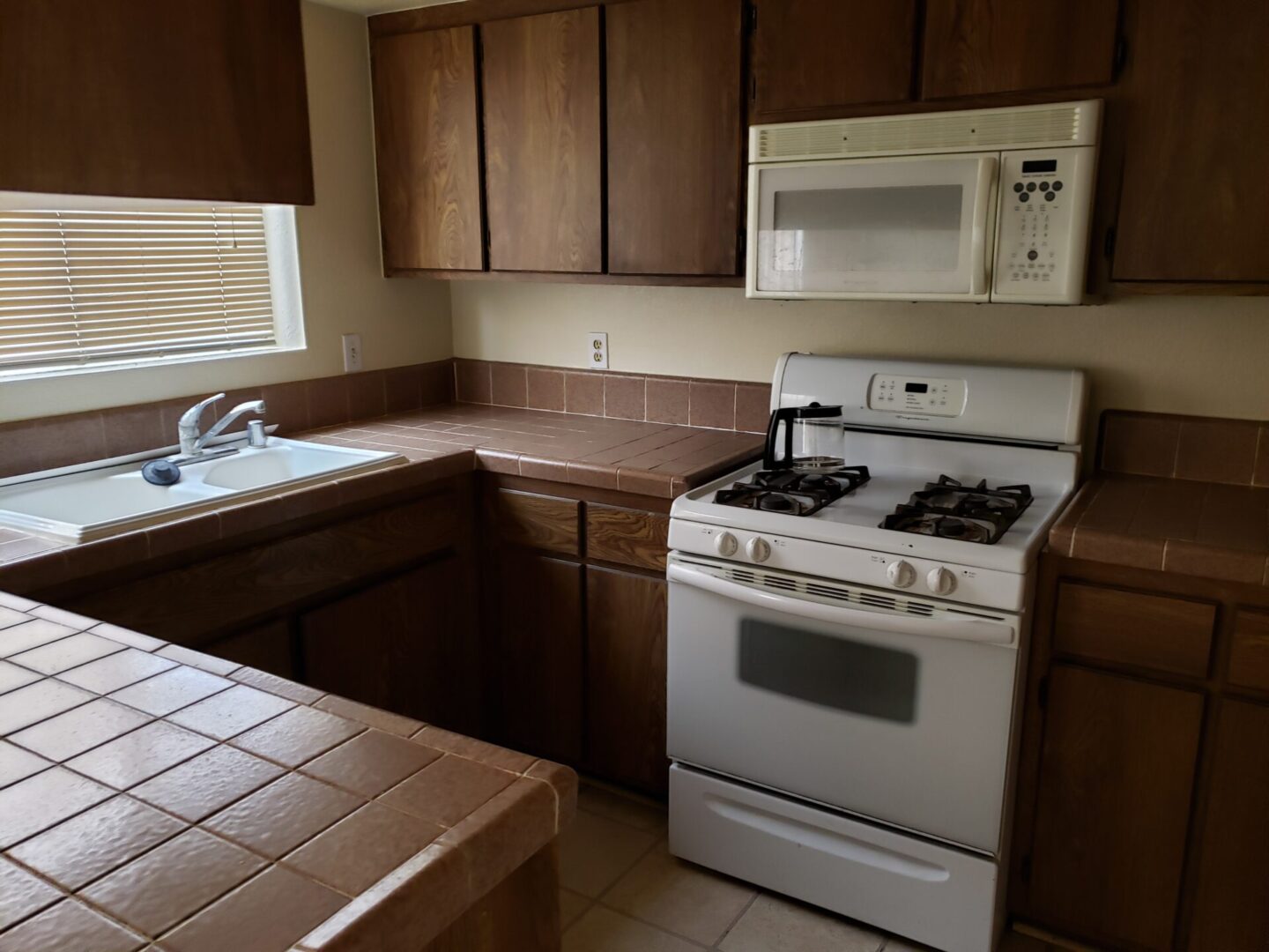 Small kitchen with gas stove and tiled countertops