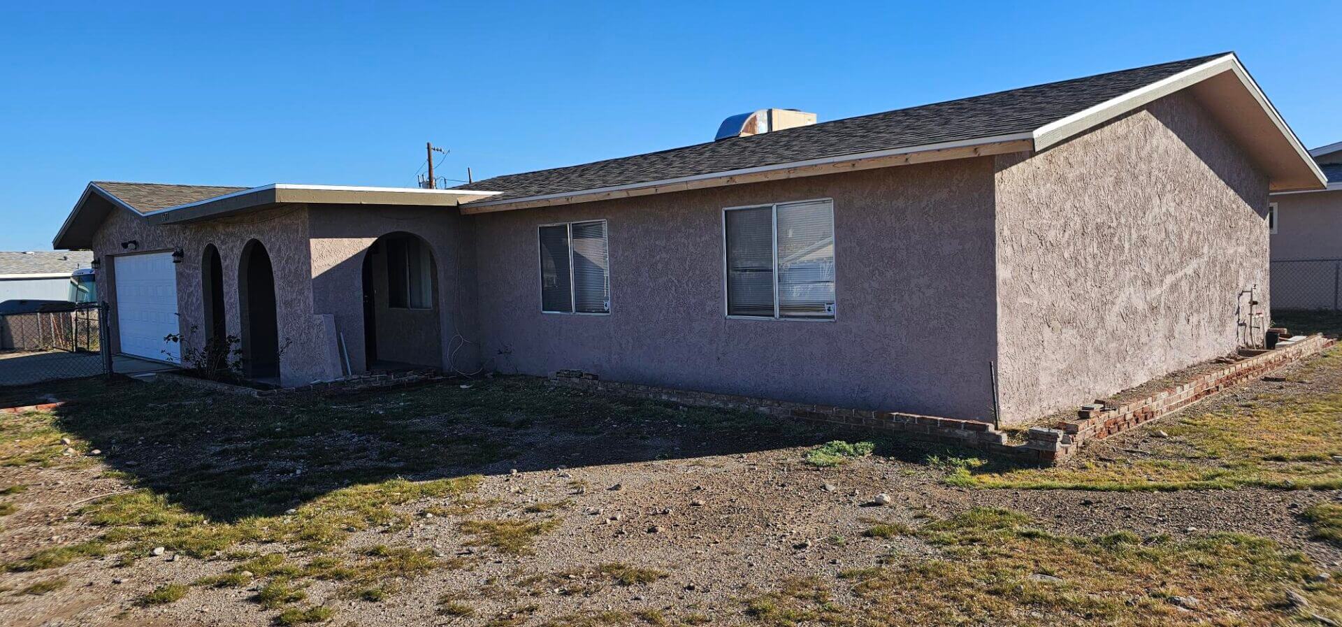Single-story stucco house with arched porch