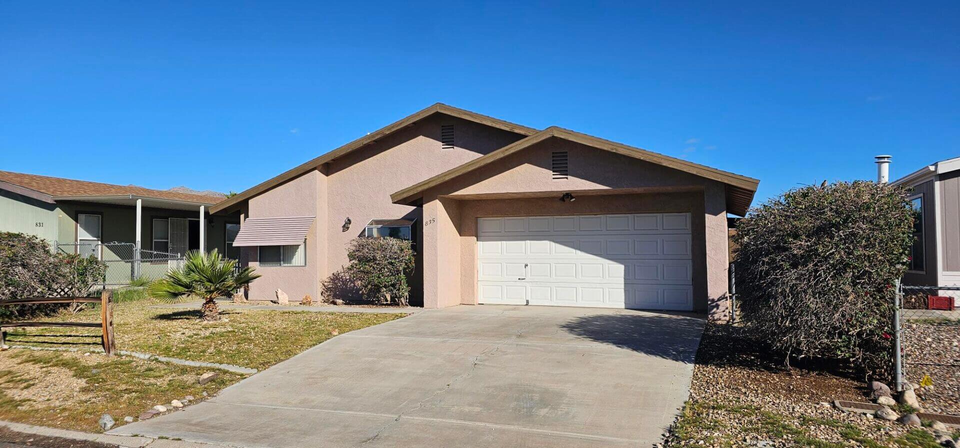 Beige single-story house with garage and driveway
