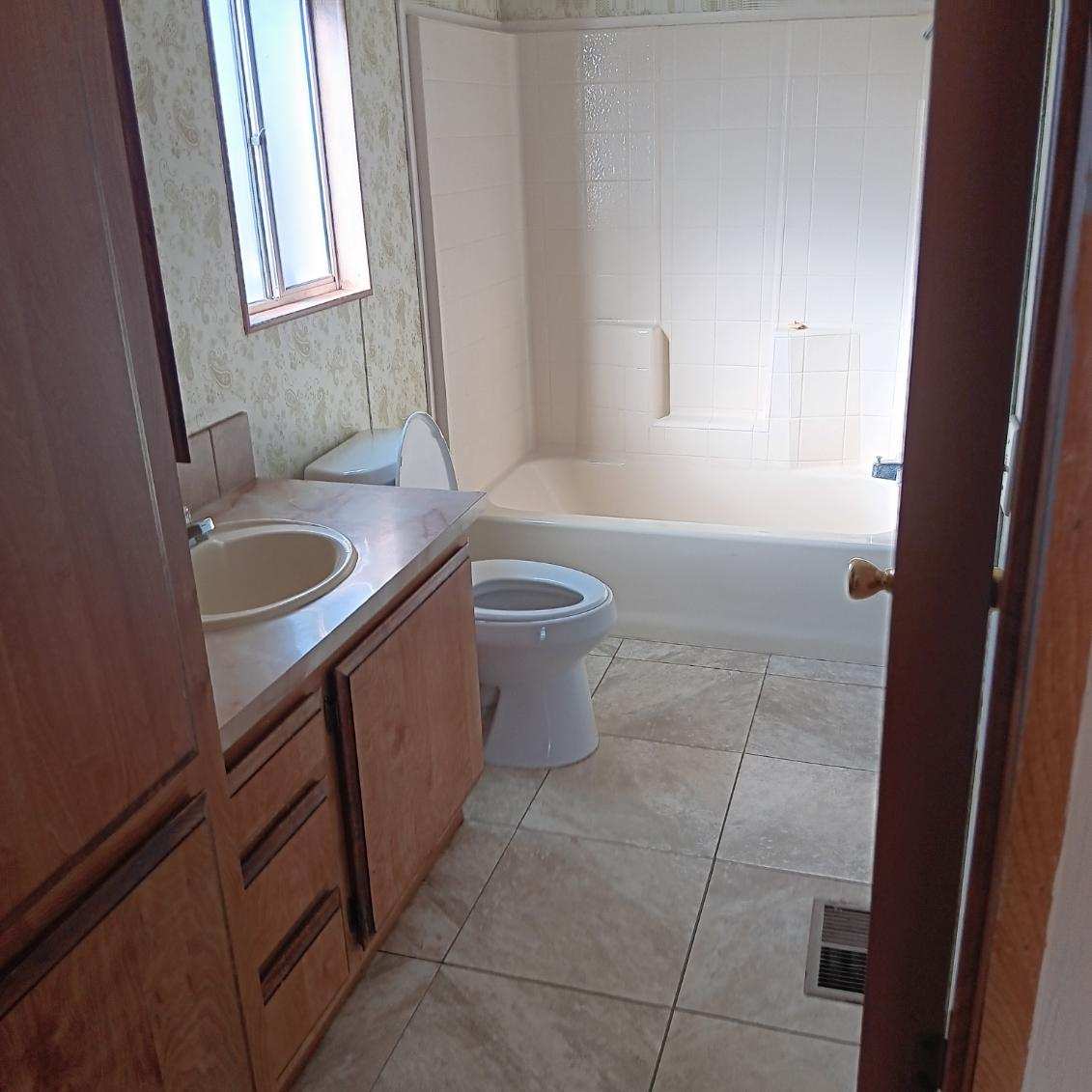 Small bathroom with bathtub, toilet, and sink