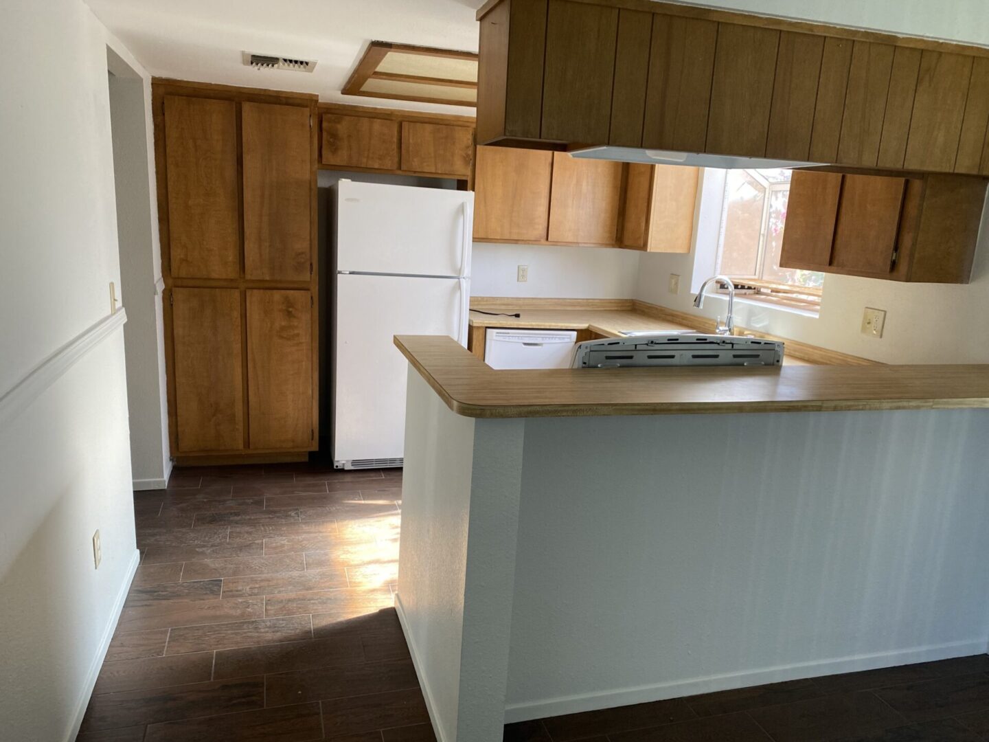 Kitchen with wooden cabinets and white refrigerator